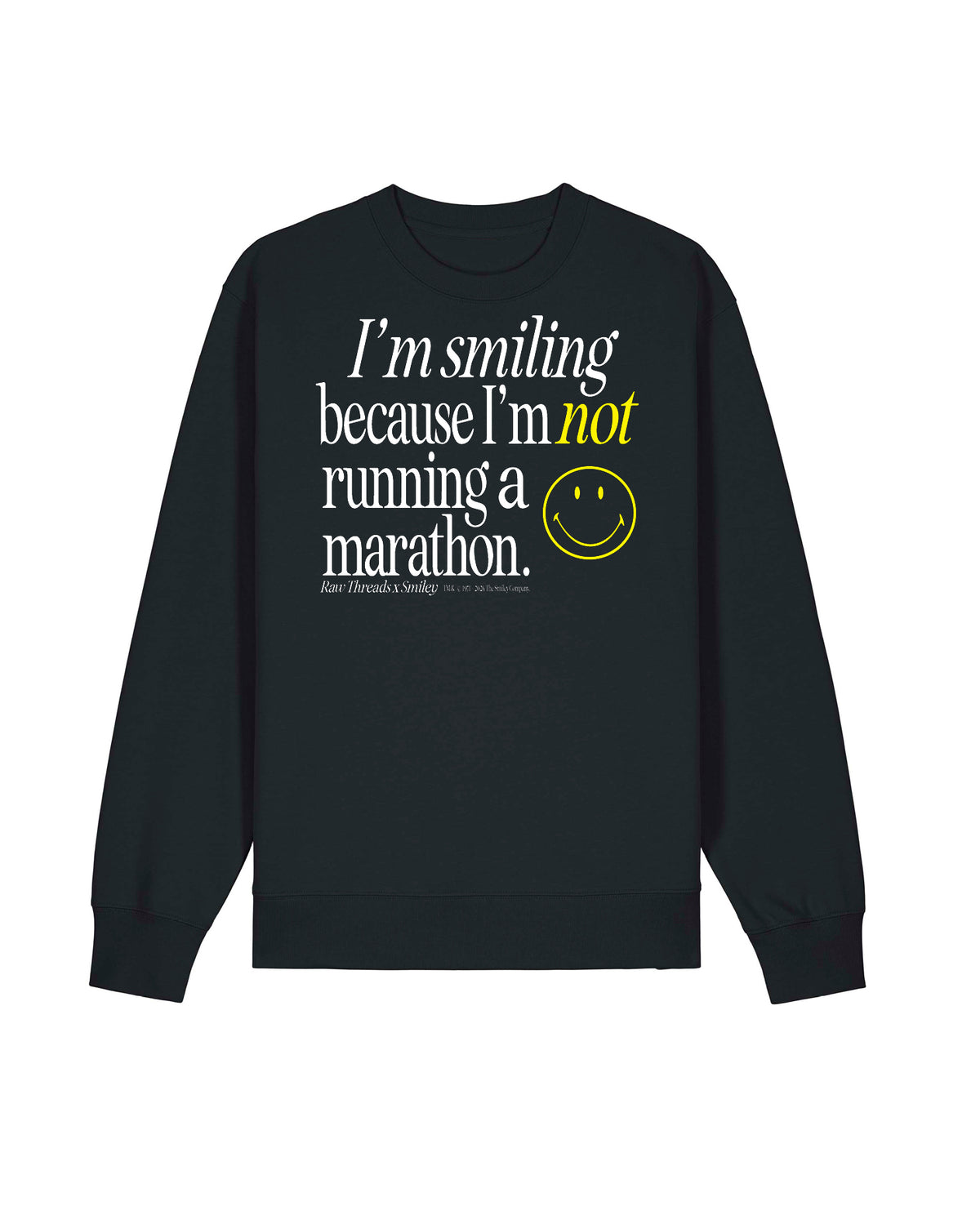 An oversized gender-neutral black crewneck sweatshirt with a graphic text print on the front reading 'I'm smiling because I'm not running a marathon.' in white and yellow, accompanied by a yellow smiley face and the Raw Threads X Smiley logo.