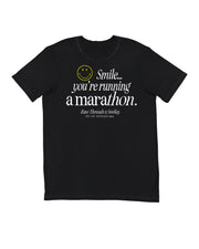 A gender-neutral running tee in crew neck style in black with a white and yellow graphic on the front that reads 'Smile you're running a marathon.' Raw Threads x Smiley logos.