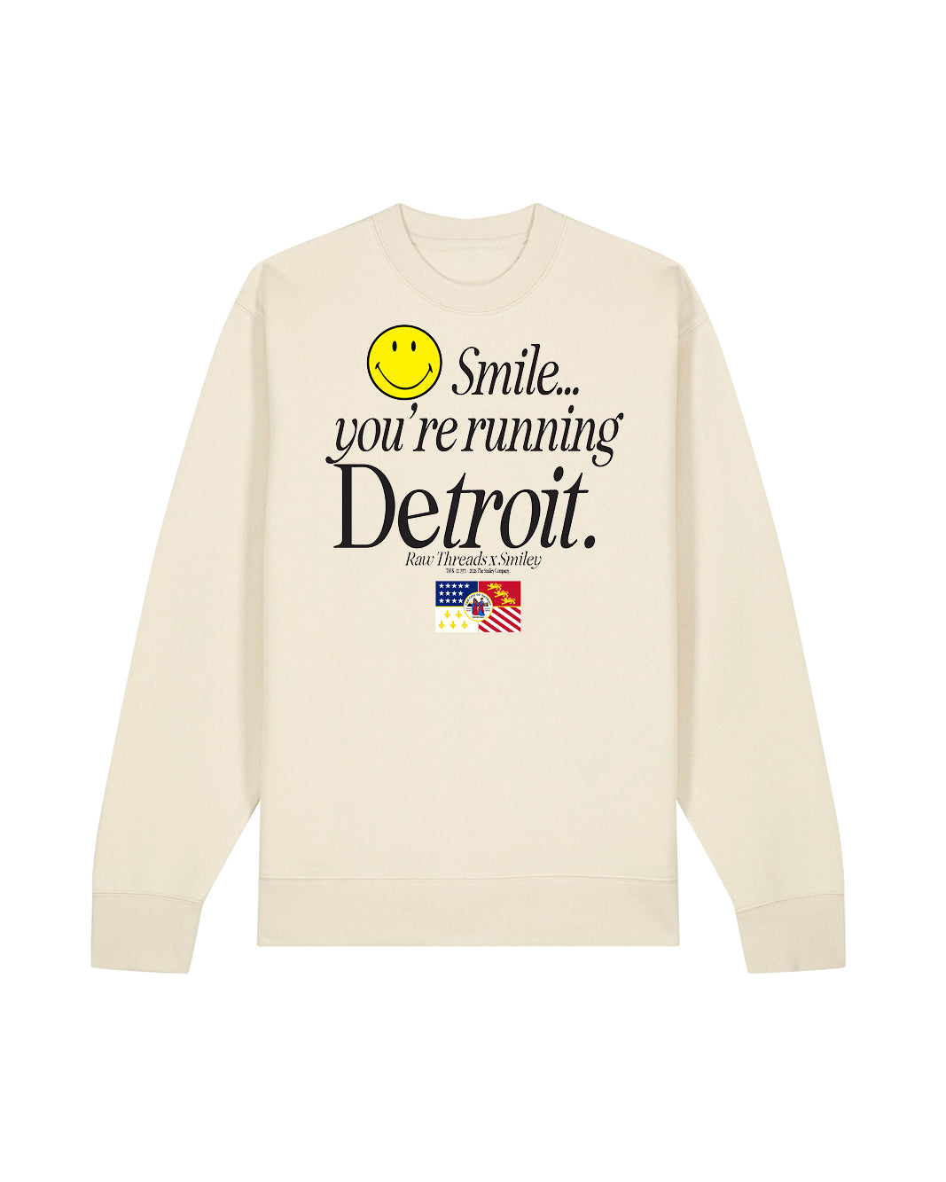 A tan gender-neutral crewneck running tee featuring a graphic print on the front with a yellow smiley face and the text 'Smile you're running Detroit' including the Detroit flag and the Raw Threads x Smiley logo.